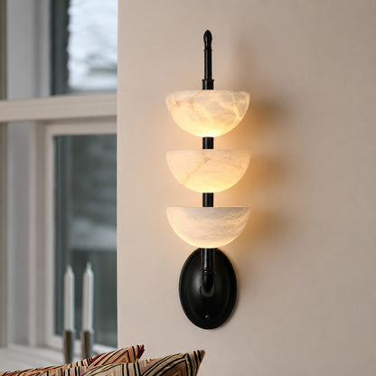 Trio alabaster wall sconce above a boutique hotel room nightstand as a designer accent