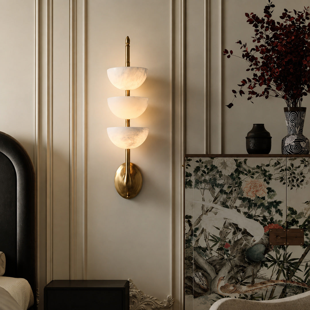 Trio alabaster wall sconce above a boutique hotel room nightstand as a designer accent