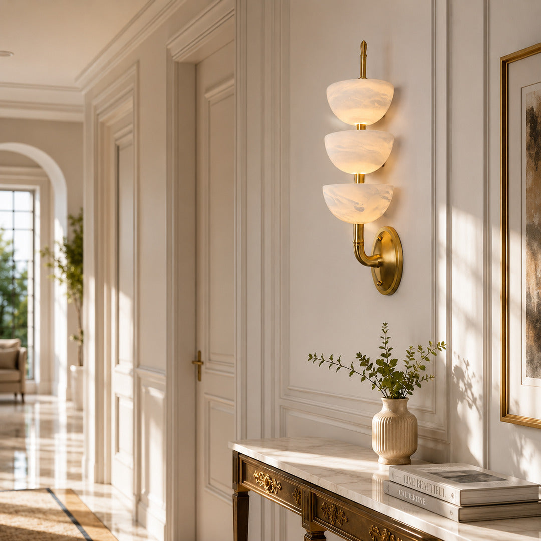 Row of Trio alabaster wall sconces lining a luxury hotel corridor with a warm glow