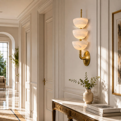 Row of Trio alabaster wall sconces lining a luxury hotel corridor with a warm glow