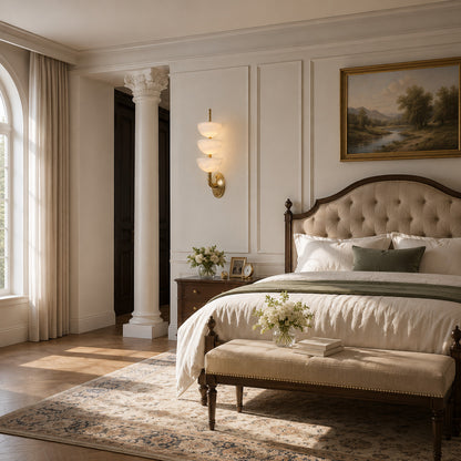 Pair of Trio alabaster wall sconces flanking a bed for symmetrical warm bedside lighting