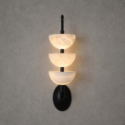 Black-frame Trio alabaster wall sconce as a modern accent on a bedroom wall