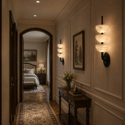 Row of Trio alabaster wall sconces adding warm rhythmic accents along a hallway