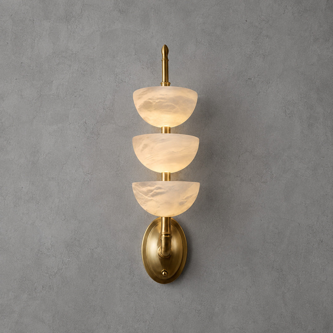 Brass-frame Trio alabaster wall sconce as a warm sculptural accent on a living room wall
