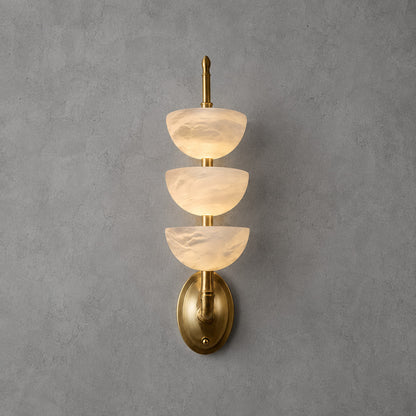 Brass-frame Trio alabaster wall sconce as a warm sculptural accent on a living room wall