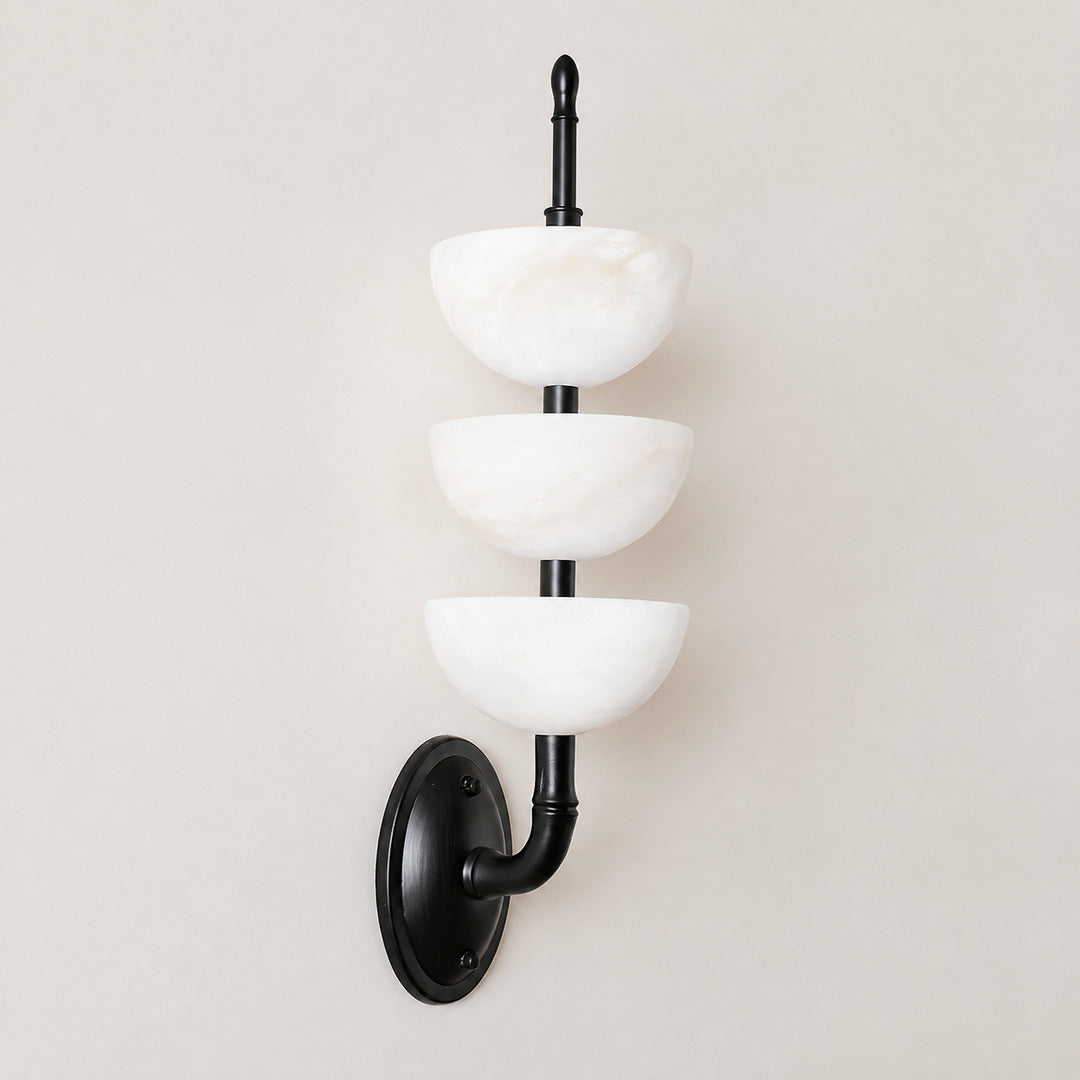 Close-up of the three vertical alabaster tube shades on the Trio wall sconce