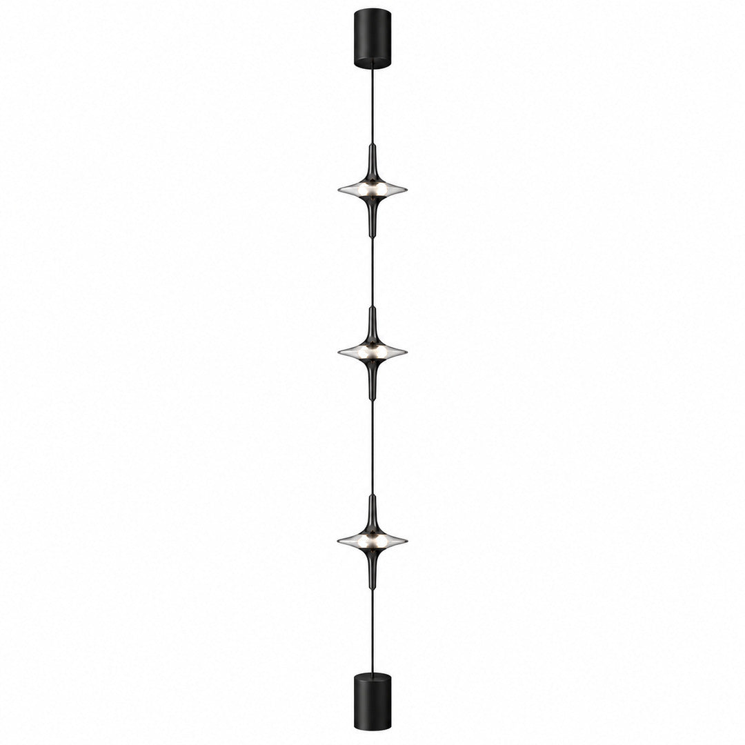 Black Trottola floor to ceiling lamp with three crystal LED heads casting star-shaped light on a wall