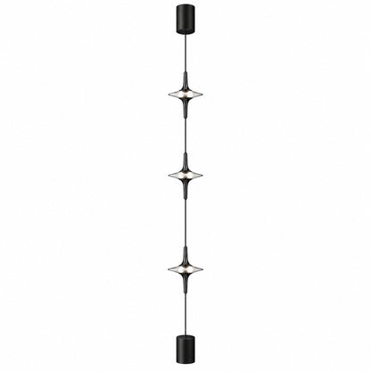 Black Trottola floor to ceiling lamp with three crystal LED heads casting star-shaped light on a wall