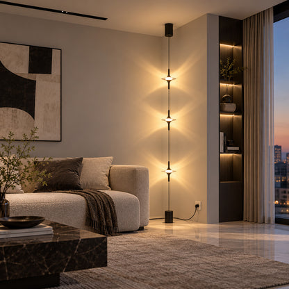 Chrome Trottola floor to ceiling lamp beside a sofa casting star-shaped light on the wall