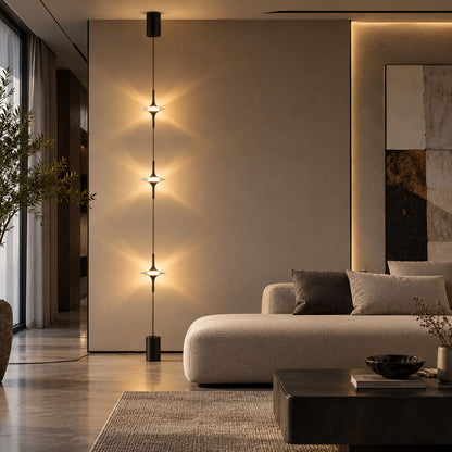 Black Trottola lamp behind a low sofa creating a column of star light on a plain wall