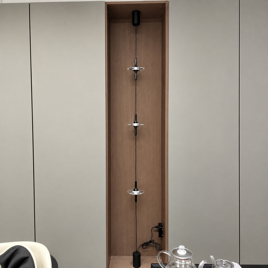 Black Trottola floor to ceiling lamp on a white wall in a minimalist modern interior