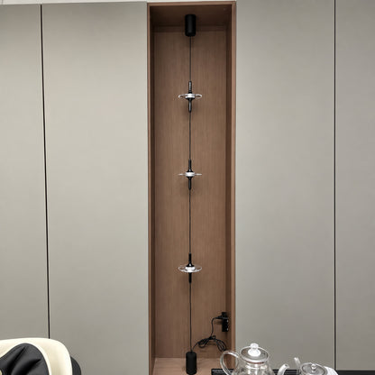 Black Trottola floor to ceiling lamp on a white wall in a minimalist modern interior