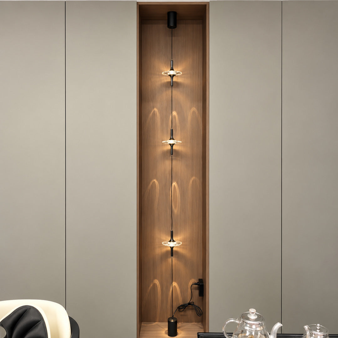Black Trottola floor to ceiling lamp on a white wall in a minimalist modern interior