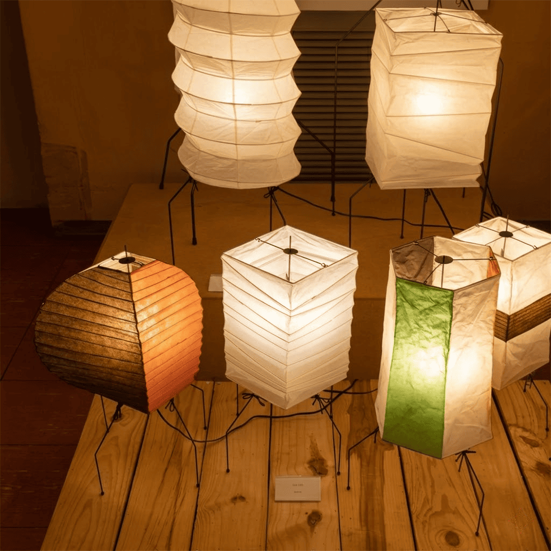 UF2-31N Washi paper table lamp with warm internal glow, handcrafted rice paper shade on black metal tripod legs.