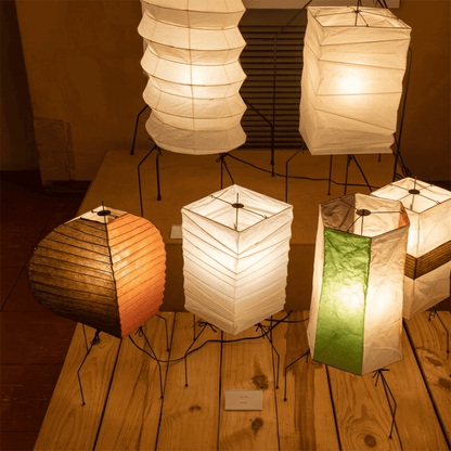 UF2-31N Washi paper table lamp with warm internal glow, handcrafted rice paper shade on black metal tripod legs.