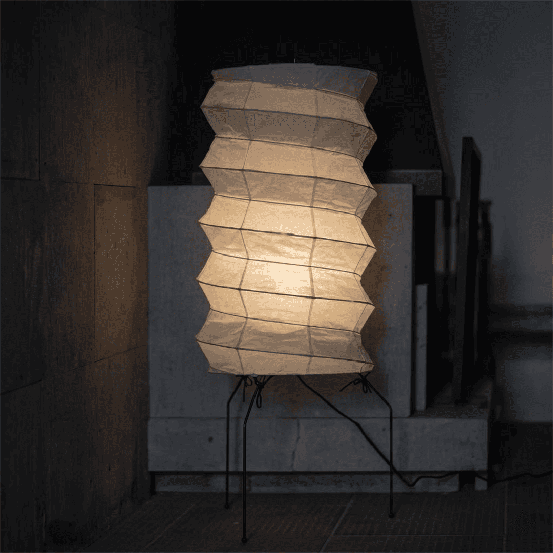 UF2-31N Washi paper table lamp with warm internal glow, handcrafted rice paper shade on black metal tripod legs.