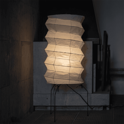 UF2-31N Washi paper table lamp with warm internal glow, handcrafted rice paper shade on black metal tripod legs.