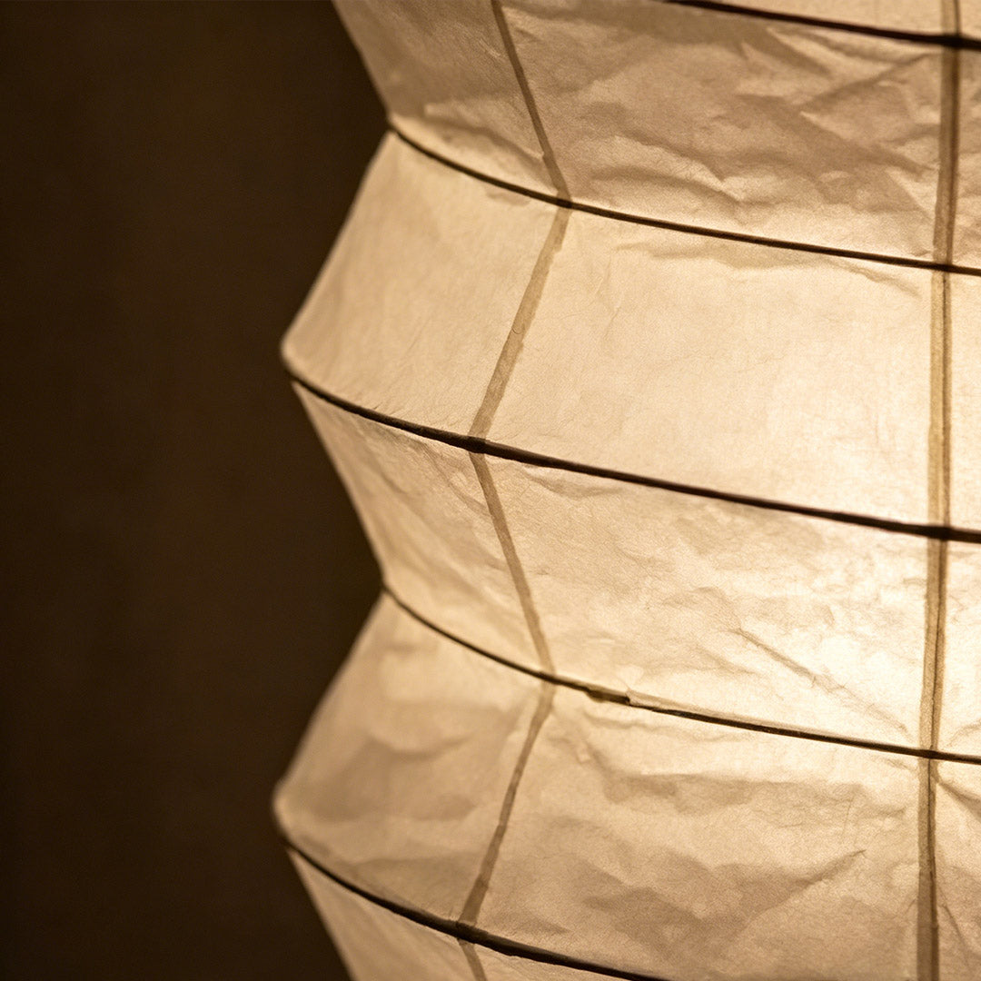 UF2-31N Washi paper table lamp with warm internal glow, handcrafted rice paper shade on black metal tripod legs.