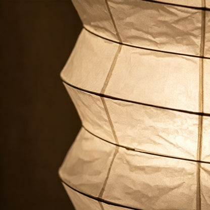 UF2-31N Washi paper table lamp with warm internal glow, handcrafted rice paper shade on black metal tripod legs.