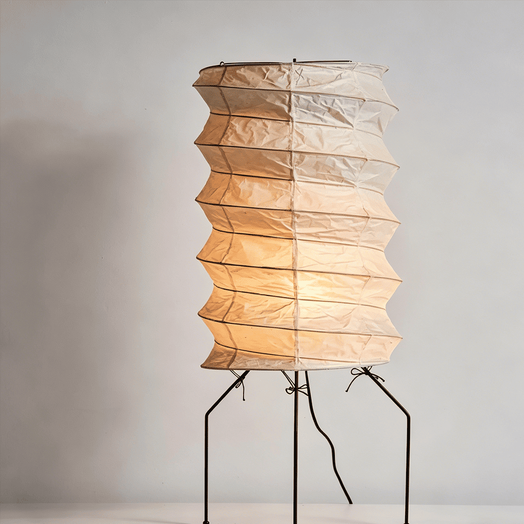 UF2-31N Washi paper table lamp with warm internal glow, handcrafted rice paper shade on black metal tripod legs.
