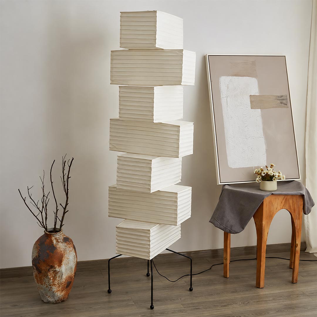 Unlit UF4-L10 washi paper stacked tower floor lamp standing next to ceramic art vases in an artistic studio