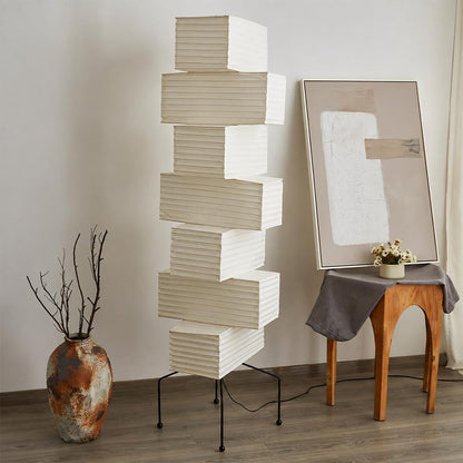 Unlit UF4-L10 washi paper stacked tower floor lamp standing next to ceramic art vases in an artistic studio