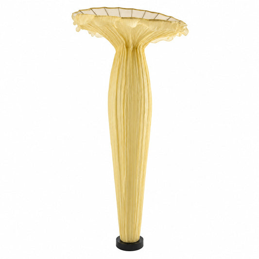 Vaso fabric floor lamp with a sculptural vase-shaped shade glowing warm in a living room corner