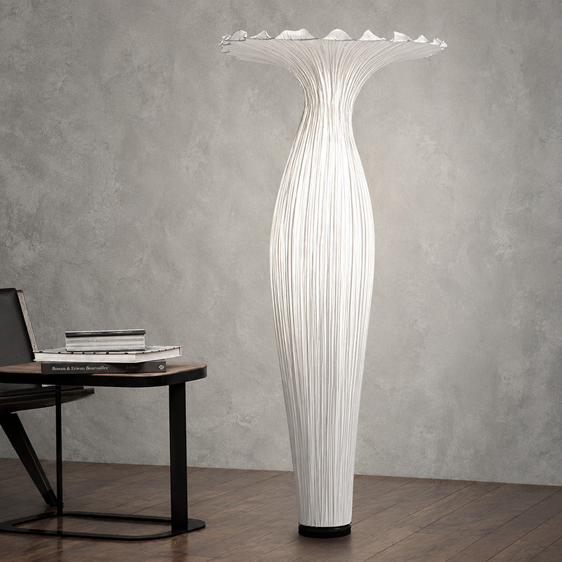 Vaso fabric floor lamp casting a soft warm glow over a corner reading chair
