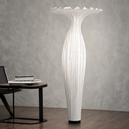 Vaso fabric floor lamp casting a soft warm glow over a corner reading chair