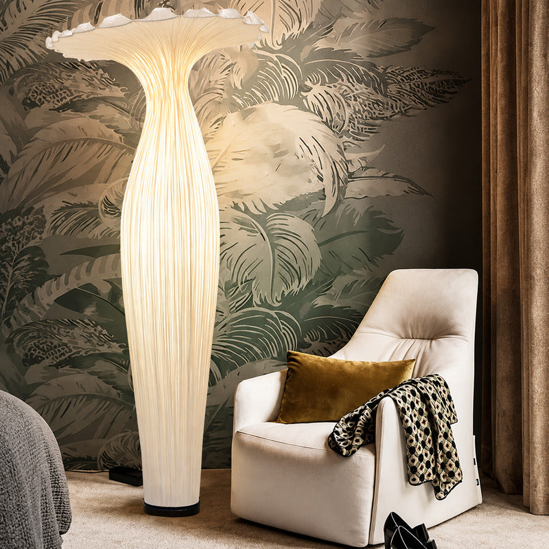 Vaso fabric floor lamp casting a soft warm glow over a corner reading chair