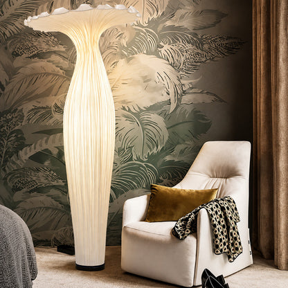 Vaso fabric floor lamp casting a soft warm glow over a corner reading chair
