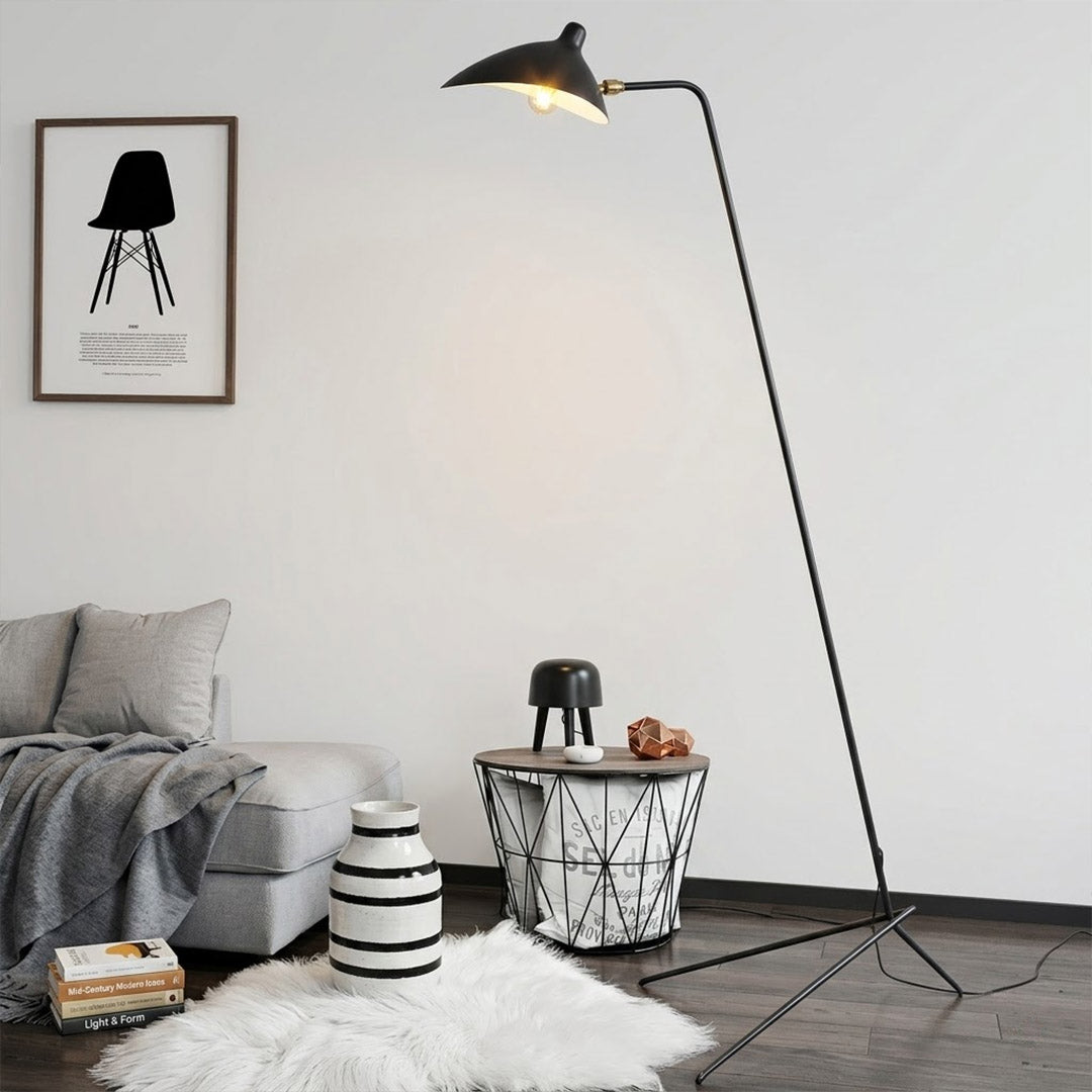 Vega tripod floor lamp behind sofa corner positioned long articulated arm reaching over seating area modern interior
