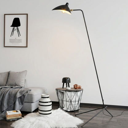 Vega tripod floor lamp behind sofa corner positioned long articulated arm reaching over seating area modern interior