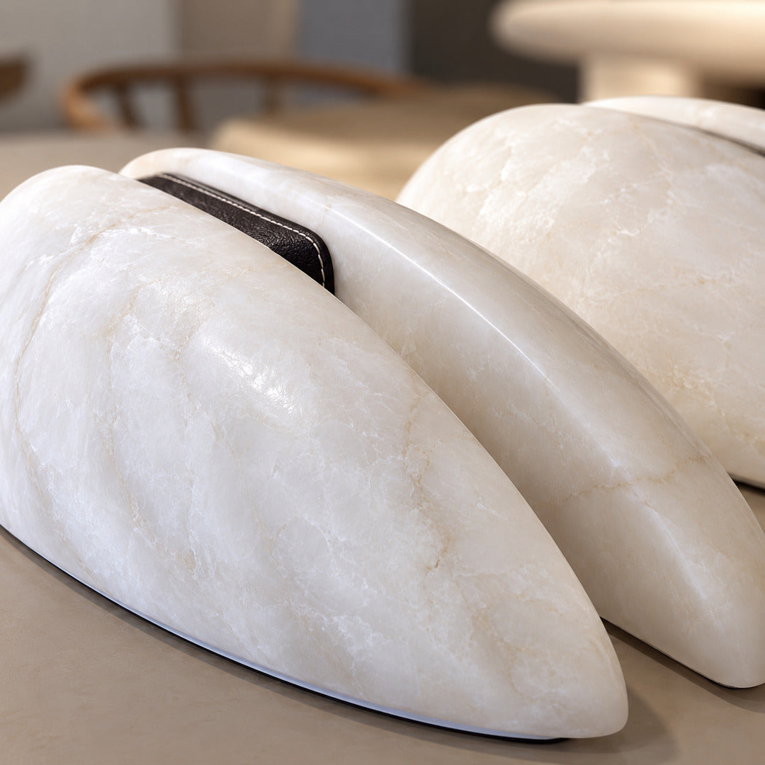 Detail of the dark leather accent band at the center of the Velo alabaster sconce