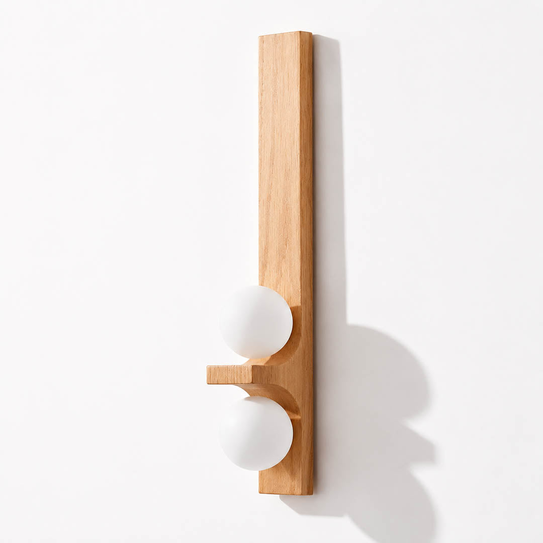 Verena double wall sconce tall oak light wood two white glass globes illuminated warm glow white background front view
