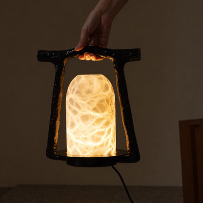 Warm evening glow of the Volta alabaster table lamp in a dark room