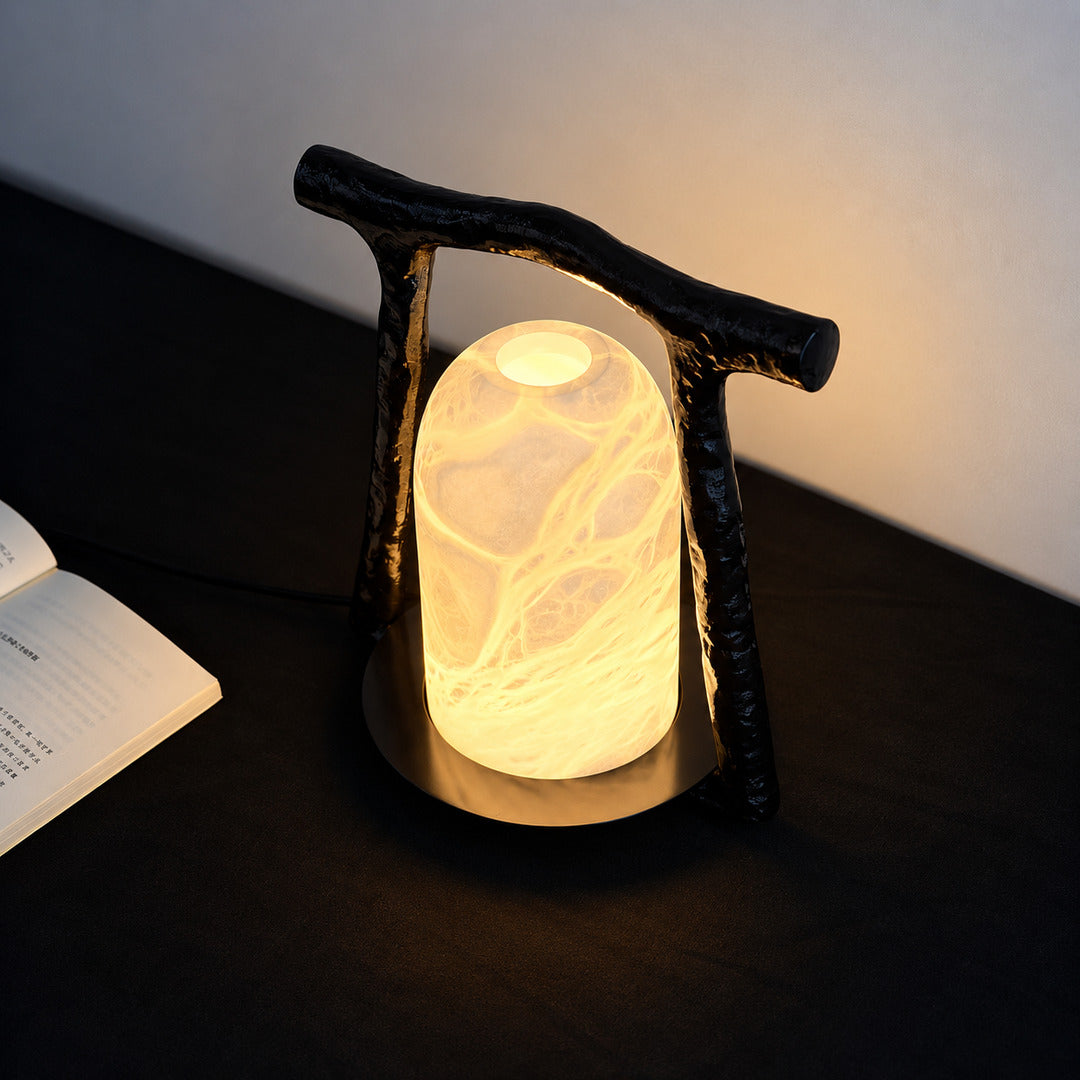 Volta alabaster table lamp glowing on an open bookshelf