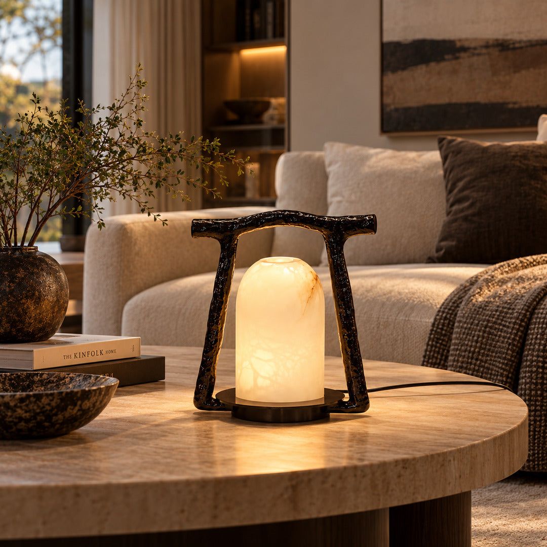Volta alabaster table lamp on a side table beside a sofa