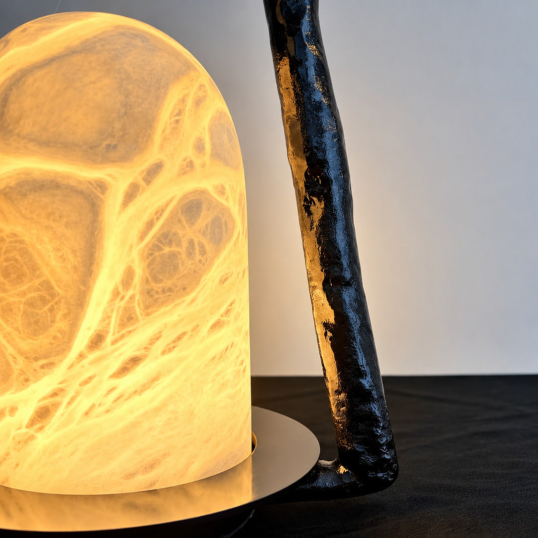 Detail of the textured black arch frame of the Volta alabaster table lamp