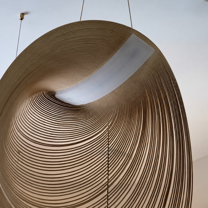 Close-up of the layered precision-bent wood form of the Voluta pendant light