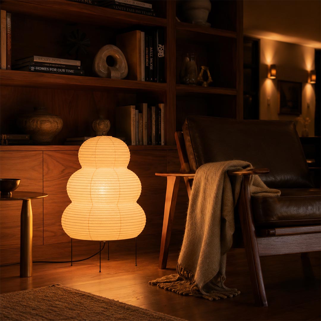 Warm ambient glow from a Washi Paper 25N Mochi Lamp in a dark-toned mid-century modern living room by Stuber Lighting.