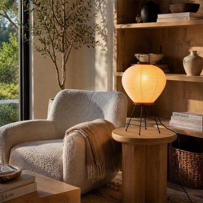 Aesthetic Washi Paper 3A Lantern Lamp casting a soft amber glow on a side table next to a plush lounge chair by Stuber Lighting.