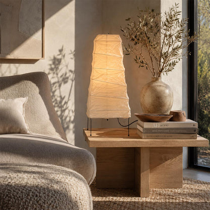 Minimalist Washi Paper 4N Table Lamp casting an organic glow in a cozy contemporary lounge corner by Stuber Lighting.