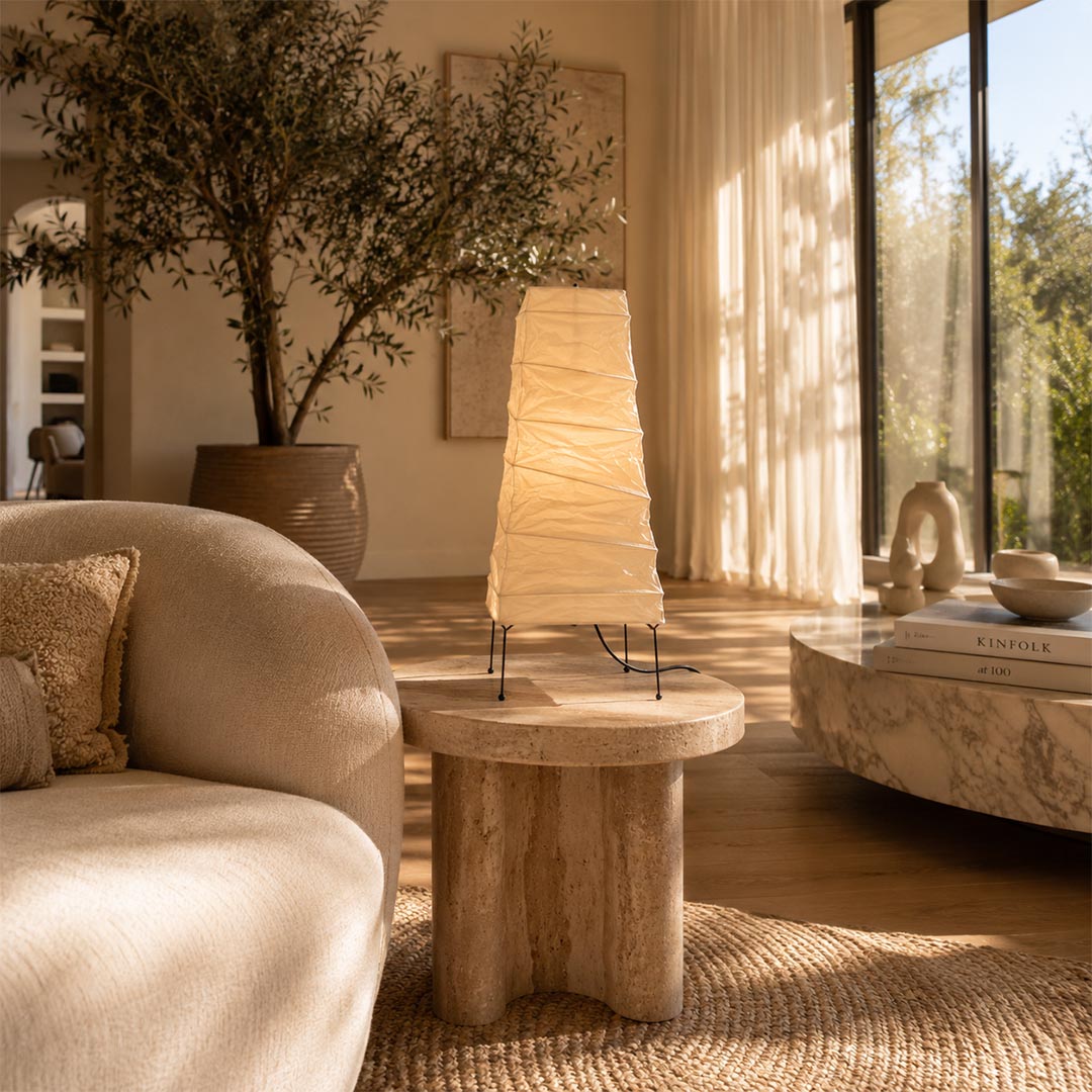 Warmly lit Washi Paper 4N Table Lamp styled on a rustic wooden side table next to a boucle sofa by Stuber Lighting.
