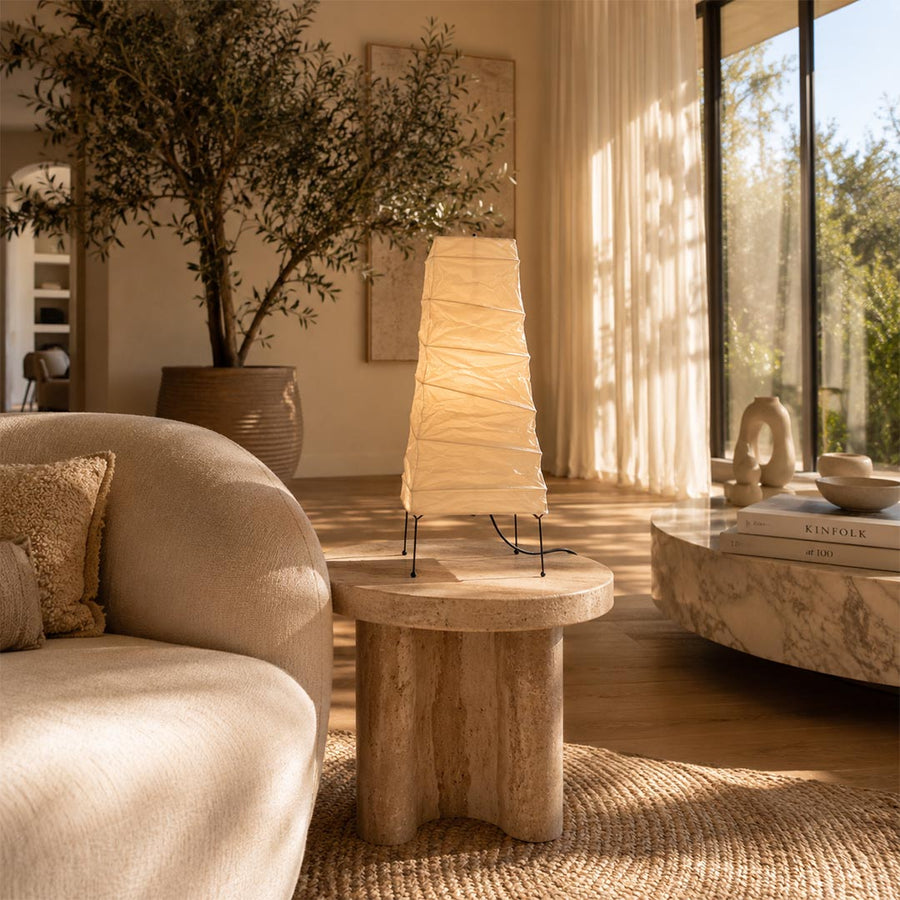 Warmly lit Washi Paper 4N Table Lamp styled on a rustic wooden side table next to a boucle sofa by Stuber Lighting.