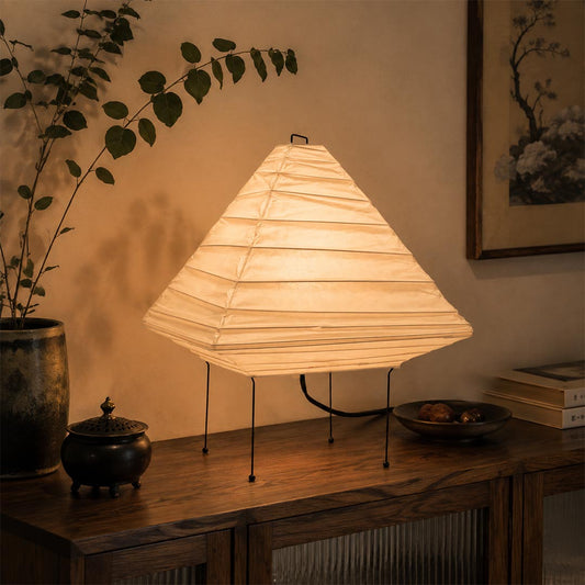 Close-up view of the 5X washi paper pyramid table lamp showing its geometric lantern shade and warm light on a wooden console