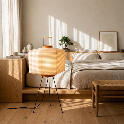 Sculptural square Washi Paper 9A Bedside Table Lamp on a wooden platform flooring in a serene bedroom by Stuber Lighting.