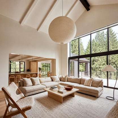 Large Washi paper sphere pendant light hanging in a minimalist Japandi style bedroom with warm light.