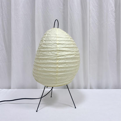 Unlit white washi paper tall tripod table lamp displaying its organic lantern texture on a clean white desk