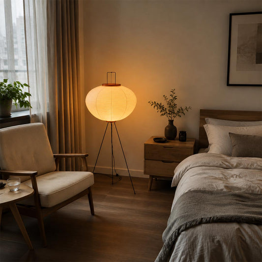 Cozy bedroom with a warm glowing washi paper tripod floor lamp placed beside the bed